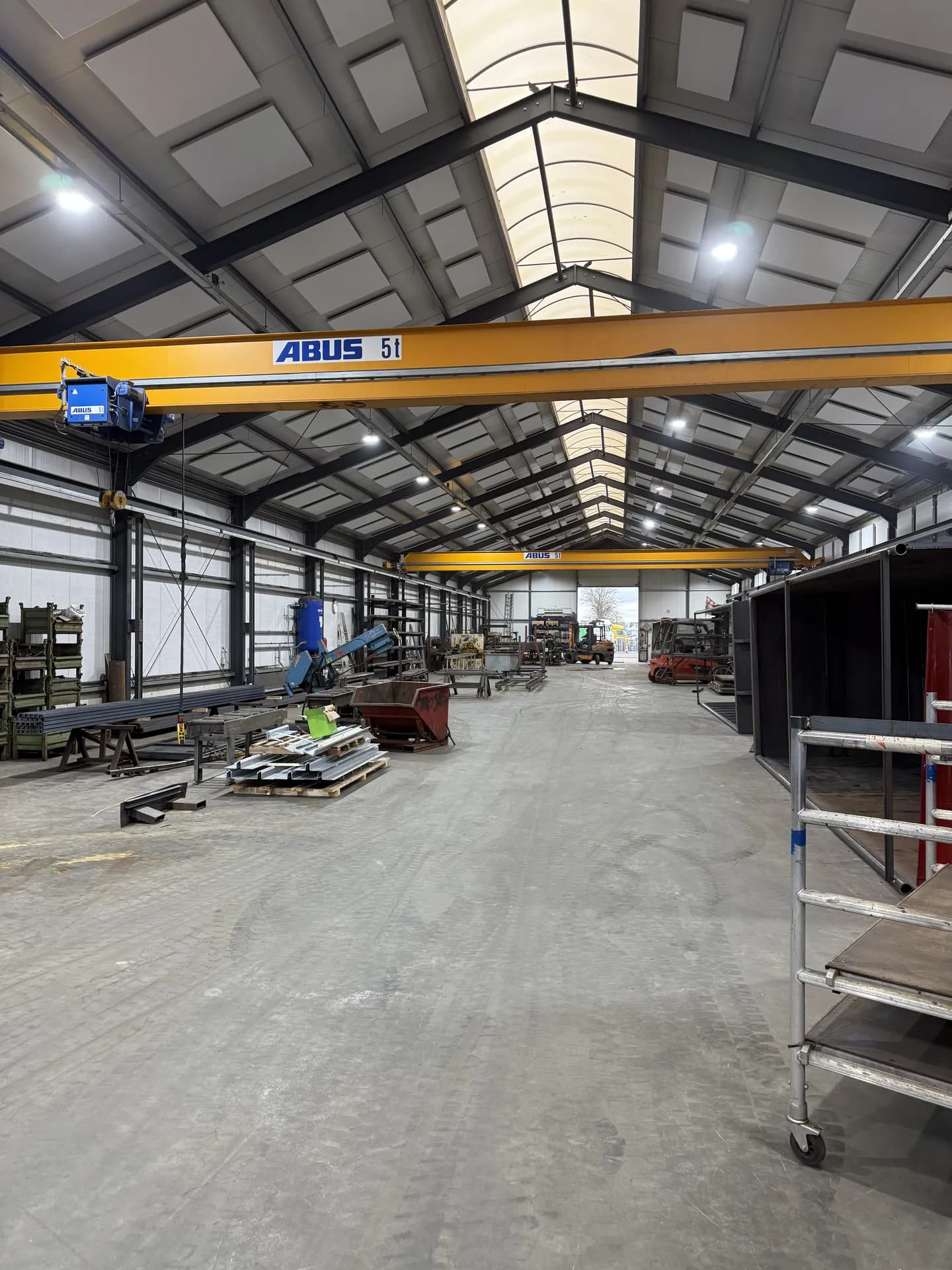 Productiehal van Vernooy Containers met bovenloopkranen onder highbay-verlichting